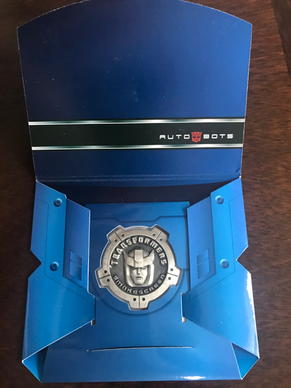 [EN STOCK] Accesorio Moneda Metálica Conmemorativa - Transformers MP-19 Smokescreen marca Hasbro / Takara